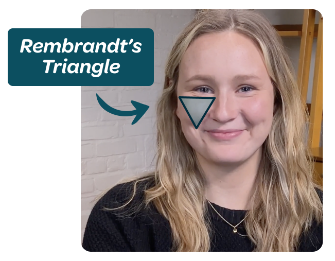 image showing the rembrandt's triangle effect of 3-point lighting: a triangle of light high up on the shadowed cheek of the video subject